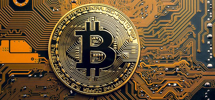 Goldene Bitcoin-Münze liegt auf einem Mainboard