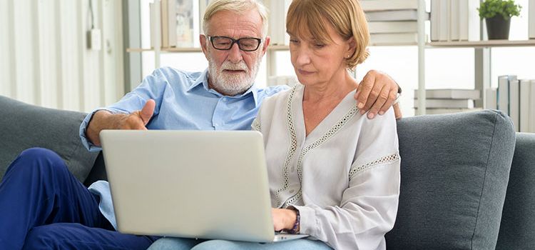 Älteres Paar am Laptop bei einer digitalen Kontoeröffnung