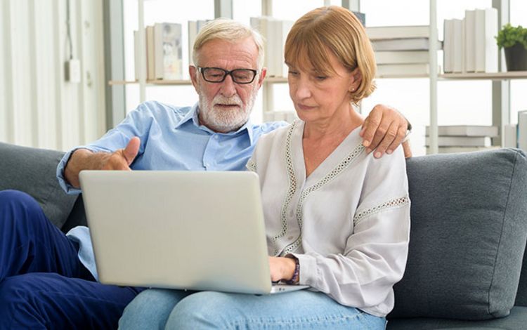 Älteres Paar am Laptop bei einer digitalen Kontoeröffnung