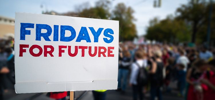 Demonstration der Klimajugend mit Schild im Vordergrund: Fridays for Future