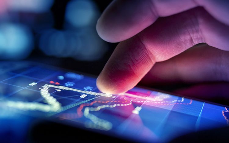 Hand mit Smartphone, ein User checkt die Börsenkurse