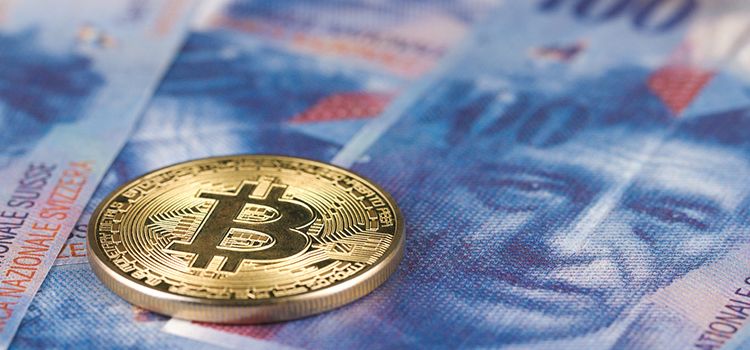 Bitcoin als Münze auf einer Schweizer Banknote