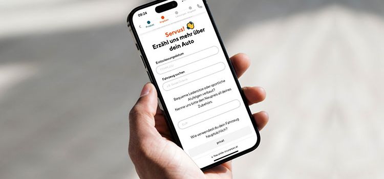 Hand mit Smartphone zeigt die Versicherungs-App Smile