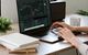 Junge Frau am Laptop beim Traden von Kryptowährungen