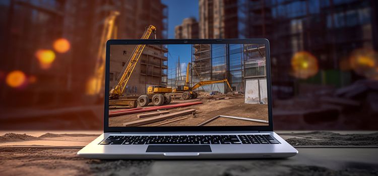 Blick auf eine Baustelle, betrachtet durch den Monitor eines Laptops