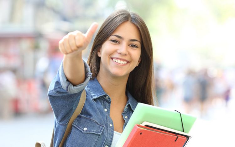 Junge Studentin lacht in die Kamera