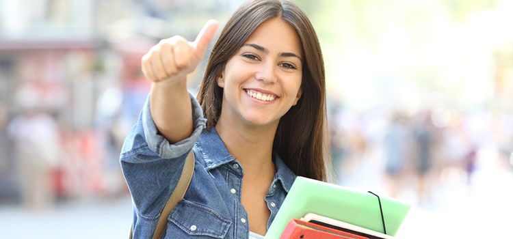 Junge Studentin lacht in die Kamera