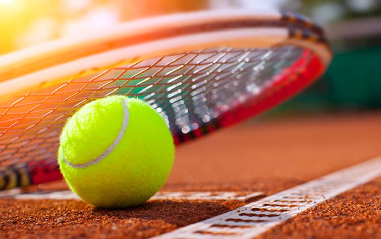 Rack und Tennisball auf einem Tennisplatz