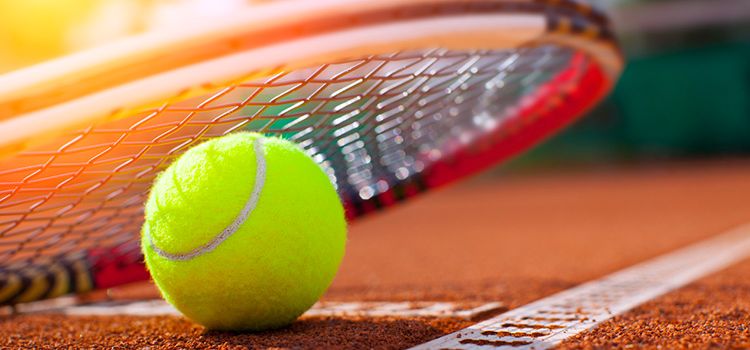 Rack und Tennisball auf einem Tennisplatz