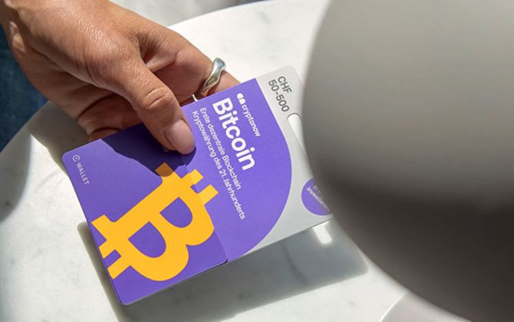 Eine Hand hält eine Bitcoin-Karte 
