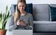 Junge Frau zu Hause am Smartphone und Laptop
