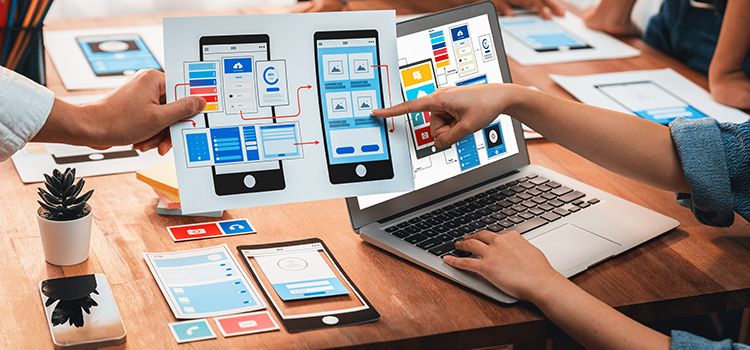 Hände, Charts und PCs auf einem Tisch als Symbol für Startups