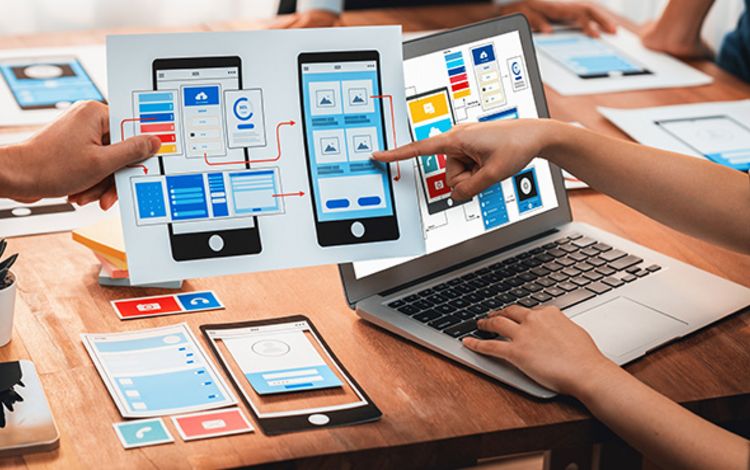 Hände, Charts und PCs auf einem Tisch als Symbol für Startups