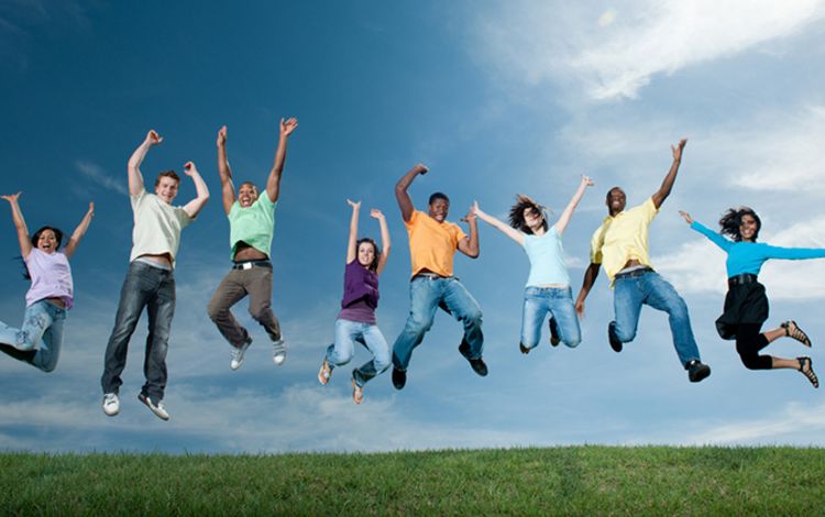 Acht junge Menschen springen gemeinsam in die Luft