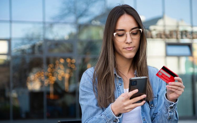 Junge Frau beim Banking am Smartphone