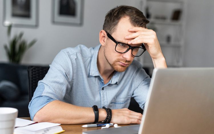 Mann vor dem Laptop mit sorgenvollem Gesicht