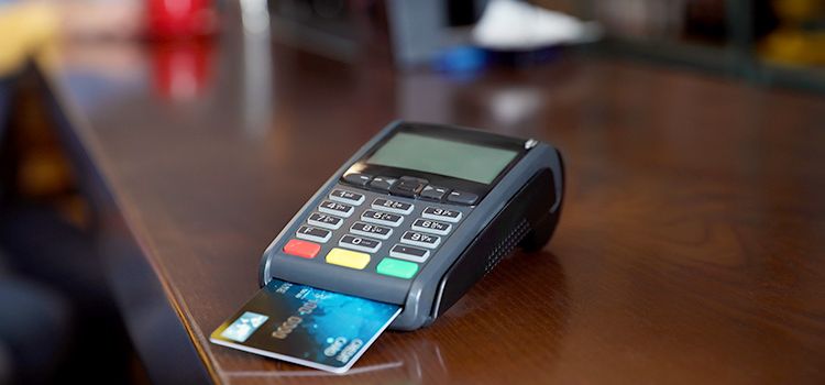 Ein Kartenterminal auf dem Tresen mit eingesteckter Kreditkarte