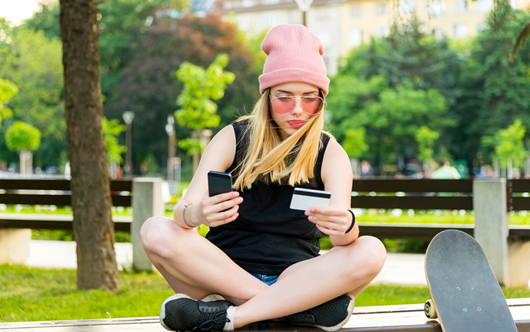 Junge Frau beim Online-Zahlen mit Kreditkarte