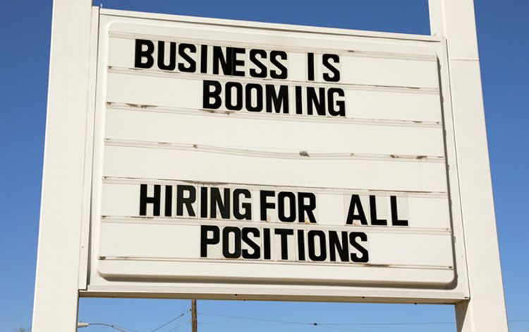 Schild an der Strasse mit Aufschrift: Business is booming, Hiring for all positions
