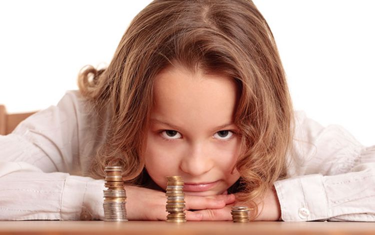 Ein Kind mit Münzen auf dem Tisch freut sich über sein kleines Vermögen