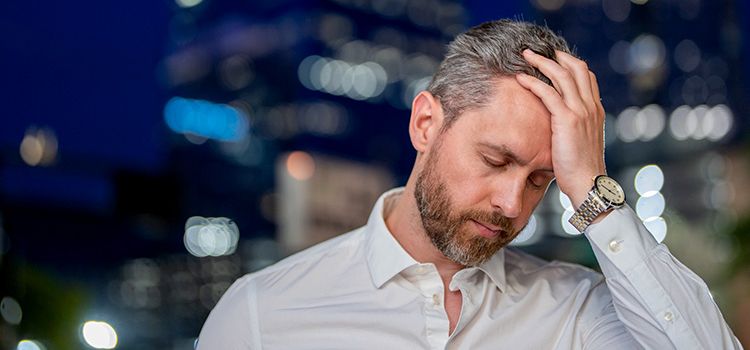 Ein Banker stöhnt unter der Last von Compliance-Vorschriften