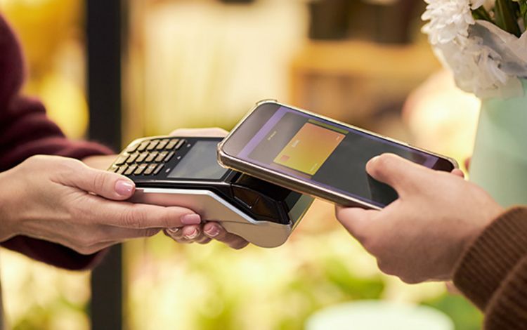 Mobiler Bezahlvorgang mit Terminal und Smartphone