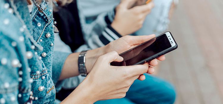 Junge Frau mit Smartphone in der Hand
