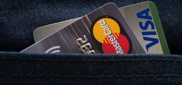 Eine Visa und eine Mastercard in einer Jeanshose
