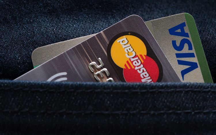 Eine Visa und eine Mastercard in einer Jeanshose
