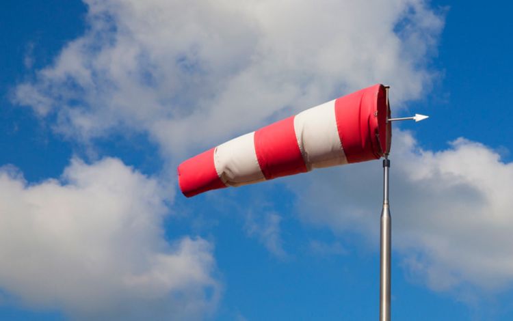 Ein aufgeblähter Windsack vor blauem Himmel und Wolken