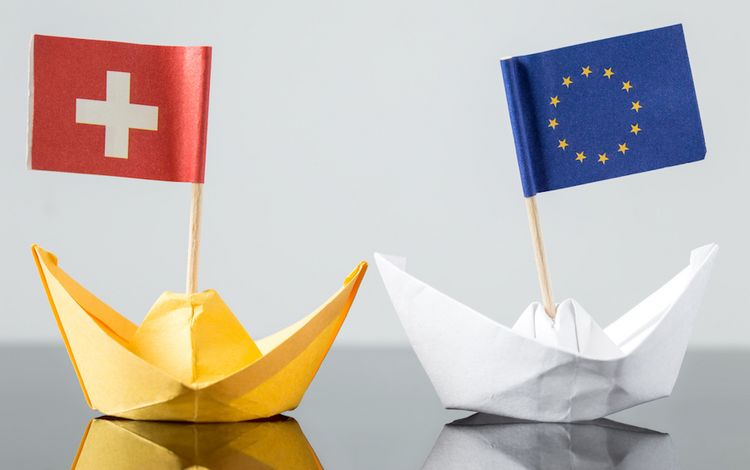 EU und die Schweiz, dargestellet mit Papierschiffchen und Flaggen