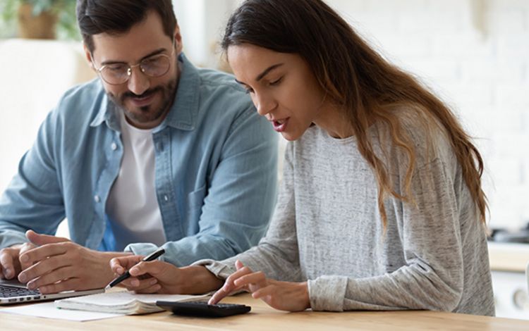 Junges Paar am Laptop prüft die Performance seiner Anlagen