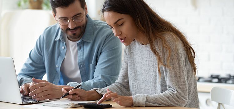 Junges Paar am Laptop prüft die Performance seiner Anlagen