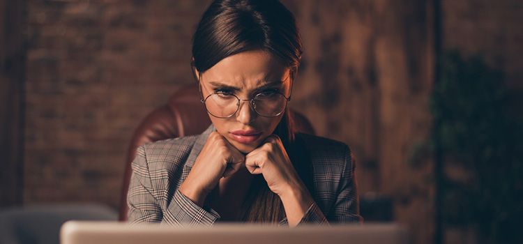 Junge Businesslady am Laptop mit kritischem Blick