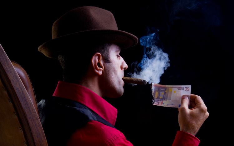 Mann zündet Zigarre mit Euroschein an