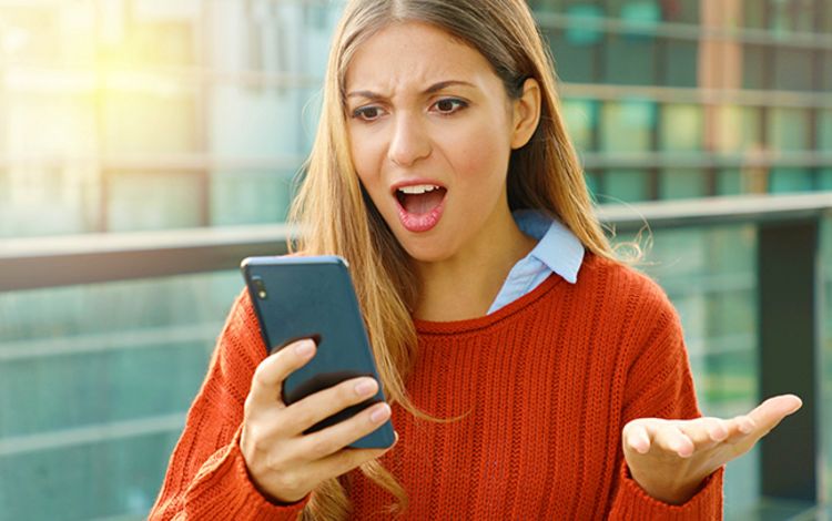 Verärgerte junge Frau am Smartphone