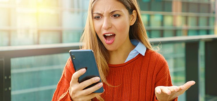 Verärgerte junge Frau am Smartphone