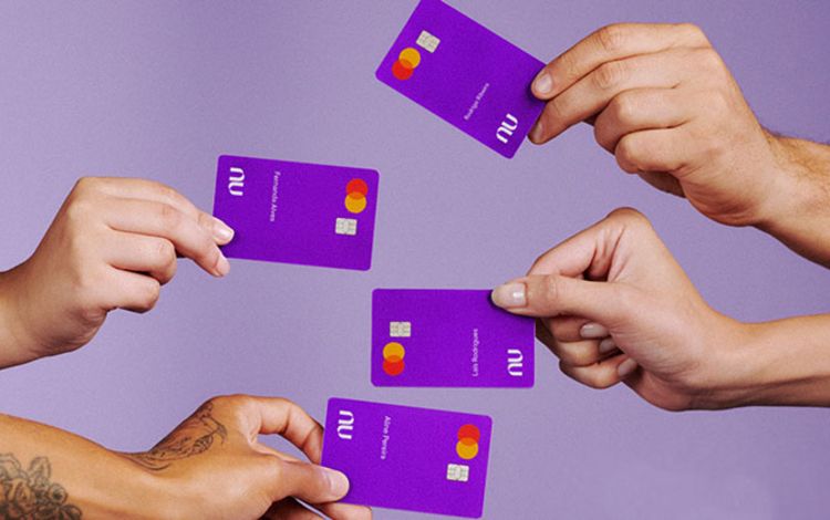 Vier Hände mit Debitkarten der Nubank