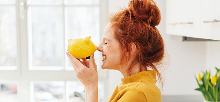 Junge Frau mit Sparschwein in der Hand