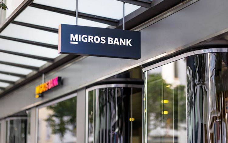 Eingang der Migros Bank mit Leuchtschrift