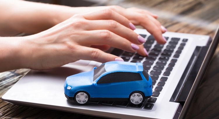 Laptop-Tastatur mit blauem Miniatur-Auto