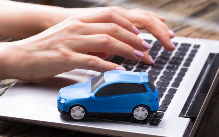 Laptop-Tastatur mit blauem Miniatur-Auto