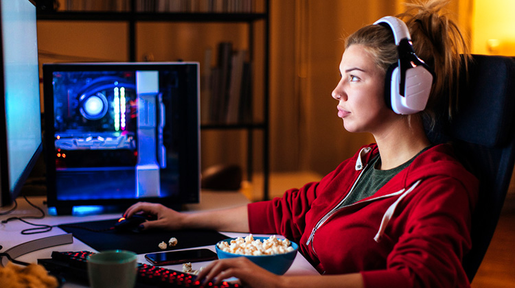 Junge Frau am PC mit Popcorn vor sich