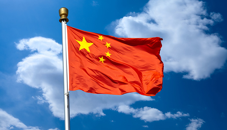 Die Flagge von China im Wind gegen blauen Himmel
