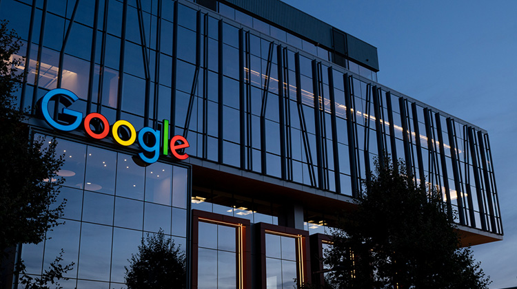 Gebäude in der Dämmerung mit beleuchtetem Logo von Google