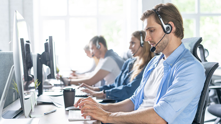 Mitarbeiterinnen und Mitarbeiter eines Callcenters der Arbeit