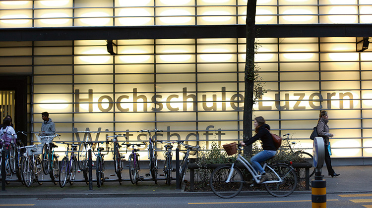 Das beleuchtete Gebäude und der Eingang der Hochschule Luzern