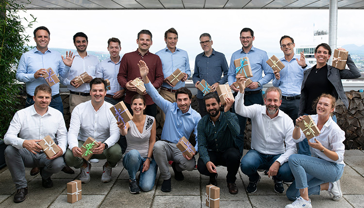 Das Team des FinTechs Loanboox, alle Mitglieder mit einem Geschenkpaket in der Hand.