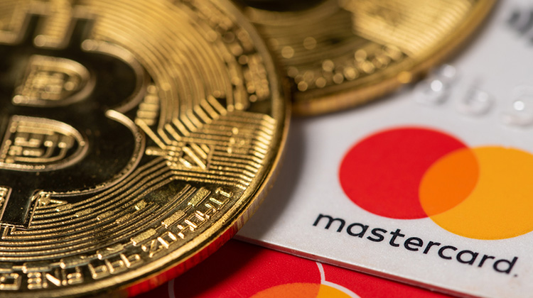 Bitcoin-Münze mit Karte von Mastercard