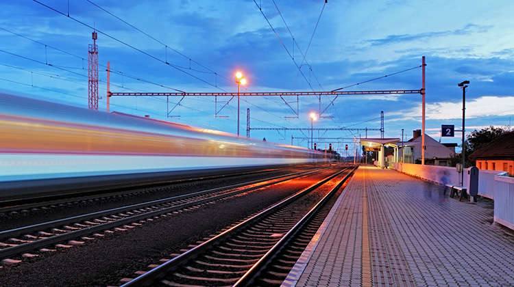 Mehrere Gleise mit Zug in schneller Fahrt